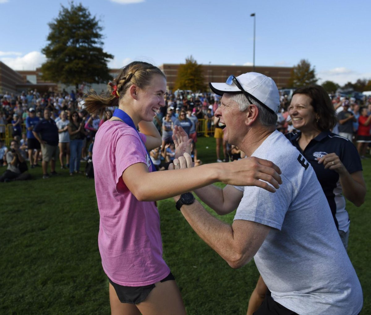 Ella Wolfe accepts medal from her coach Curt Rogers during the District 3 class 3A girls cross country championships at Big Spring High School Saturday Oct. 28, 2023.